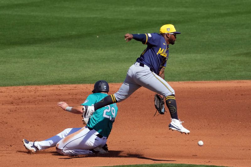 Mar 14, 2024; Peoria, Arizona, USA; Seattle Mariners catcher Cal Raleigh (29) beats a throw to Milwaukee Brewers second baseman Yonny Hernandez (63) to steal second base during the fourth inning at Peoria Sports Complex. Mandatory Credit: Joe Camporeale-USA TODAY Sports