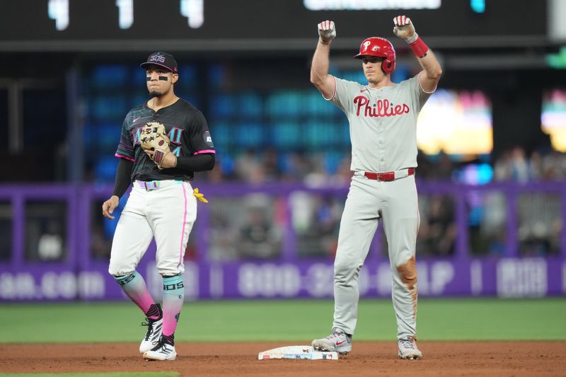 Sep 6, 2025; Miami, Florida, USA;  Philadelphia Phillies catcher J.T. Realmuto (10) celebrates a double in the fifth inning as Miami Marlins second baseman Maximo Acosta (24) looks on at loanDepot Park. Mandatory Credit: Jim Rassol-Imagn Images
