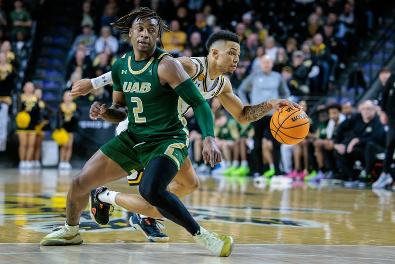 Feb 27, 2025; Wichita, Kansas, USA; Wichita State Shockers guard Xavier Bell (1) brings the ball up court around UAB Blazers guard Ja'Borri McGhee (2) during the second half at Charles Koch Arena. Mandatory Credit: William Purnell-Imagn Images