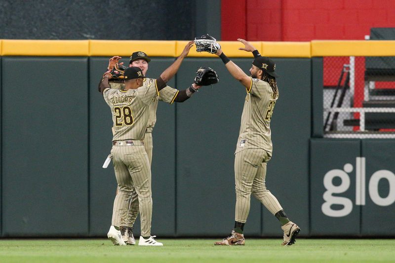 May 17, 2024; Atlanta, Georgia, USA; San Diego Padres left fielder Jose Azocar (28) and center fielder Jackson Merrill (3) and right fielder Fernando Tatis Jr. (23) celebrate after a victory against the Atlanta Braves at Truist Park. Mandatory Credit: Brett Davis-USA TODAY Sports