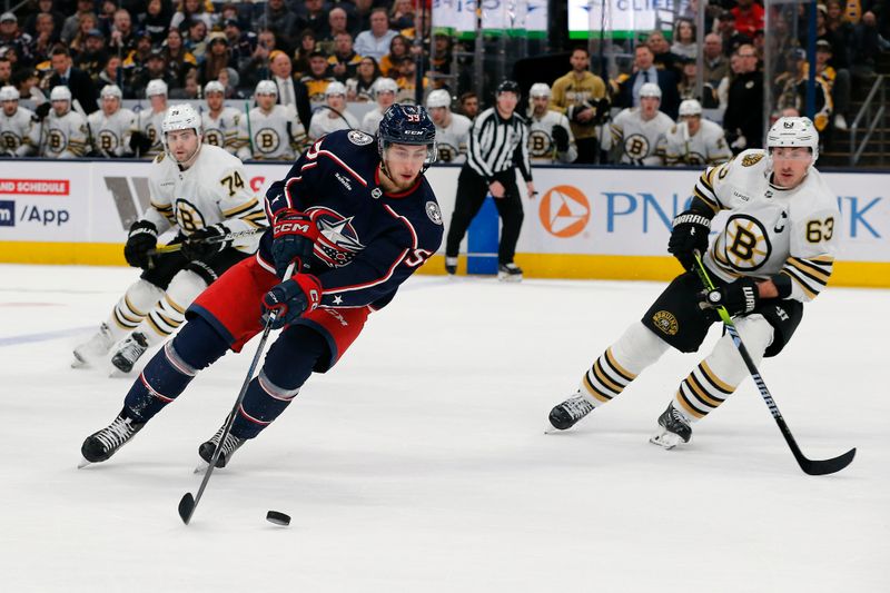 Jan 2, 2024; Columbus, Ohio, USA; Columbus Blue Jackets right wing Yegor Chinakhov (59) carries the puck as Boston Bruins left wing Brad Marchand (63) trails the play during the third period at Nationwide Arena. Mandatory Credit: Russell LaBounty-USA TODAY Sports