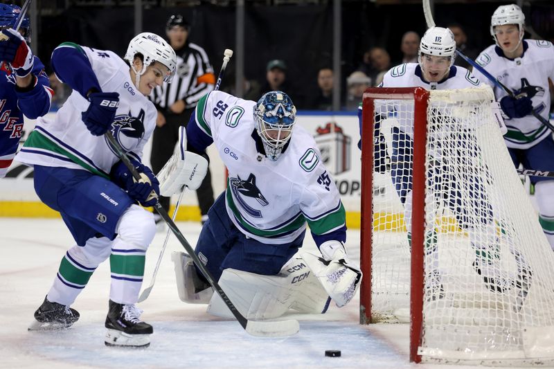 Dec 16, 2025; New York, New York, USA; Vancouver Canucks defenseman Zeev Buium (24) and goaltender Thatcher Demko (35) clear the puck from the crease during the second period against the New York Rangers at Madison Square Garden. Mandatory Credit: Brad Penner-Imagn Images