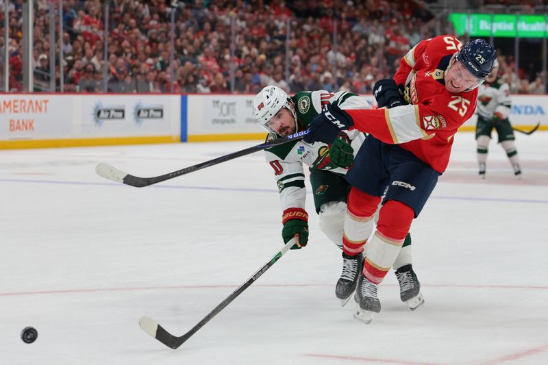 Mar 26, 2026; Sunrise, Florida, USA; Florida Panthers left wing Nolan Foote (25) shoots the puck as Minnesota Wild left wing Marcus Johansson (90) defends during the second period at Amerant Bank Arena. Mandatory Credit: Sam Navarro-Imagn Images