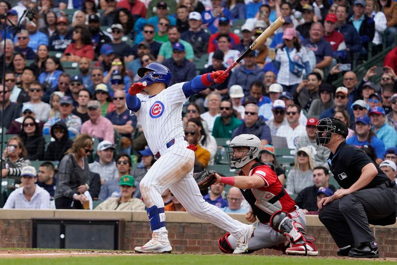 Sep 27, 2024; Chicago, Illinois, USA; Chicago Cubs catcher Miguel Amaya (9) hits a one run sacrifice fly against the Cincinnati Reds during the fifth inning at Wrigley Field. Mandatory Credit: David Banks-Imagn Images