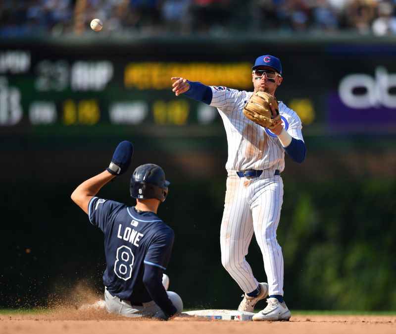 Sep 13, 2025; Chicago, Illinois, USA; Chicago Cubs second baseman Nico Hoerner (2) competes a double play after forcing out Tampa Bay Rays second baseman Brandon Lowe (8) during the ninth inning at Wrigley Field. Mandatory Credit: Patrick Gorski-Imagn Images