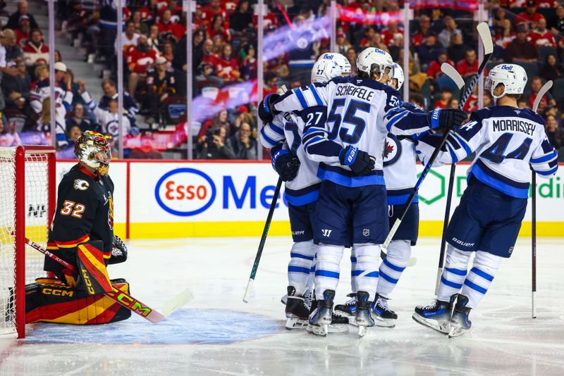 Oct 26, 2024; Calgary, Alberta, CAN; Winnipeg Jets left wing Nikolaj Ehlers (27) celebrates his goal with teammates against Calgary Flames goaltender Dustin Wolf (32) during the first period at Scotiabank Saddledome. Mandatory Credit: Sergei Belski-Imagn Images