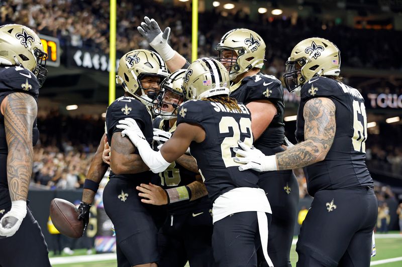 New Orleans Saints wide receiver Bub Means (16) celebrates with quarterback Spencer Rattler (18) after a touchdown during an NFL football game against the Tampa Bay Buccaneers, Sunday, Oct. 13, 2024, in New Orleans. (AP Photo/Tyler Kaufman)