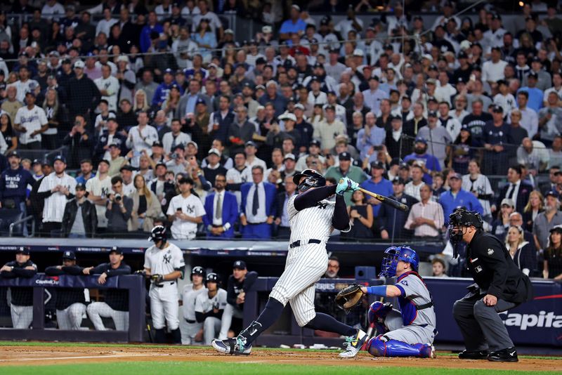 Oct 30, 2024; New York, New York, USA; New York Yankees outfielder Aaron Judge (99) hits a three run home run during the first inning against the Los Angeles Dodgers in game four of the 2024 MLB World Series at Yankee Stadium. Mandatory Credit: Brad Penner-Imagn Images