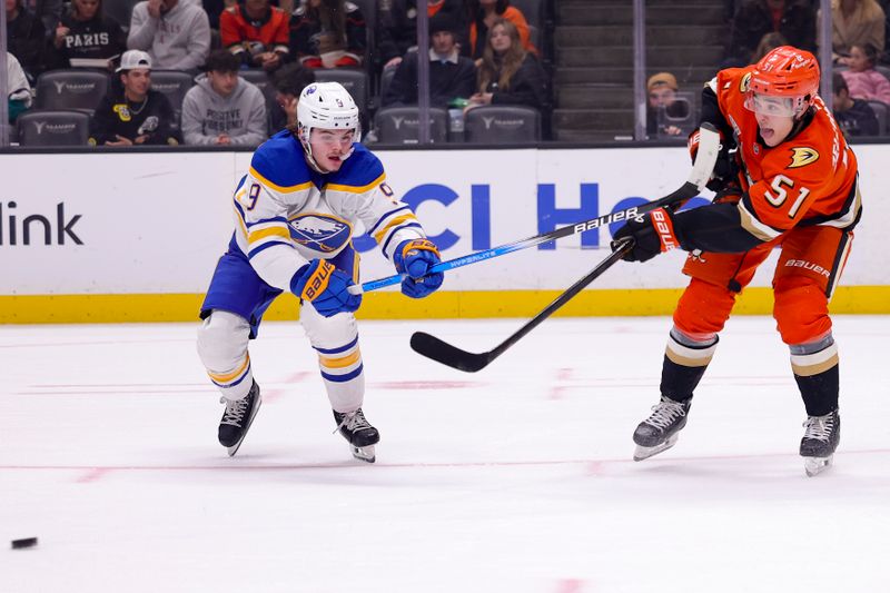 Nov 22, 2024; Anaheim, California, USA; Anaheim Ducks defenseman Olen Zellweger (51) passes against Buffalo Sabres left wing Zach Benson (9) during the first period at Honda Center. Mandatory Credit: Ryan Sun-Imagn Images