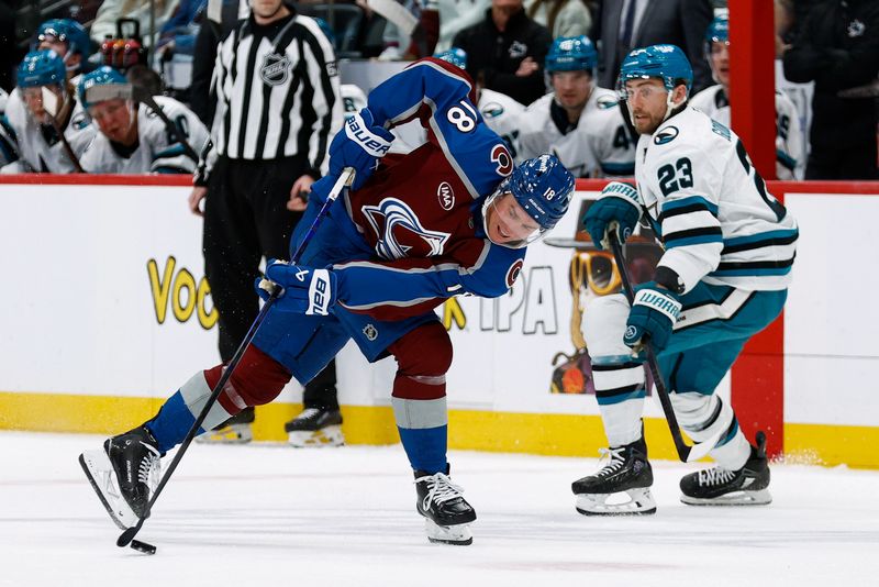 Mar 6, 2025; Denver, Colorado, USA; Colorado Avalanche center Jack Drury (18) controls the puck as San Jose Sharks right wing Barclay Goodrow (23) looks on in the second period at Ball Arena. Mandatory Credit: Isaiah J. Downing-Imagn Images