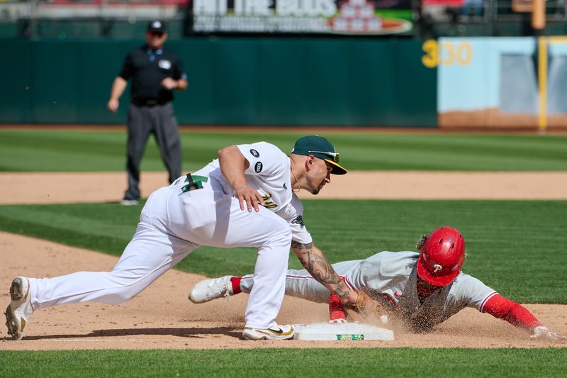 Jun 17, 2023; Oakland, California, USA; Philadelphia Phillies outfielder Cristian Pache (19) slides into third base against Oakland Athletics infielder Jace Peterson (6) during the twelfth inning at Oakland-Alameda County Coliseum. Mandatory Credit: Robert Edwards-USA TODAY Sports