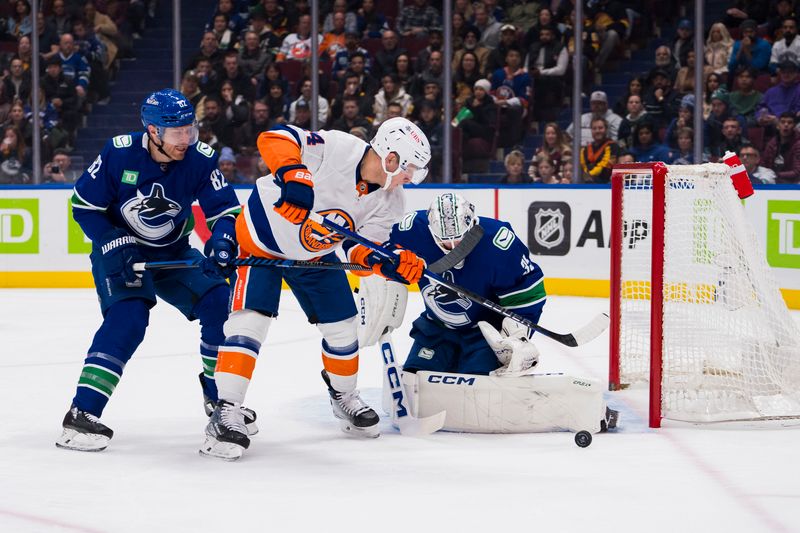 Nov 15, 2023; Vancouver, British Columbia, CAN; Vancouver Canucks goalie Thatcher Demko (35) watches the rebound as defenseman Ian Cole (82) battles with New York Islanders forward Bo Horvat (14) in the first period at Rogers Arena. Mandatory Credit: Bob Frid-USA TODAY Sports