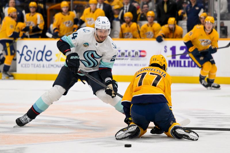 Mar 19, 2026; Nashville, Tennessee, USA;  Seattle Kraken defenseman Jamie Oleksiak (24) passes the puck under the legs of Nashville Predators right wing Luke Evangelista (77) during the second period at Bridgestone Arena. Mandatory Credit: Steve Roberts-Imagn Images