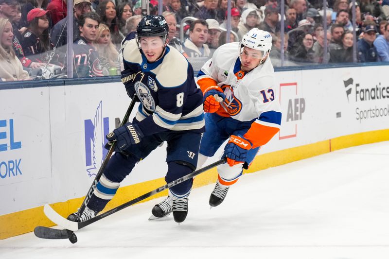 Feb 28, 2026; Columbus, Ohio, USA;  Columbus Blue Jackets defenseman Zach Werenski (8) skates with the puck against New York Islanders center Mathew Barzal (13) in the first period at Nationwide Arena. Mandatory Credit: Aaron Doster-Imagn Images