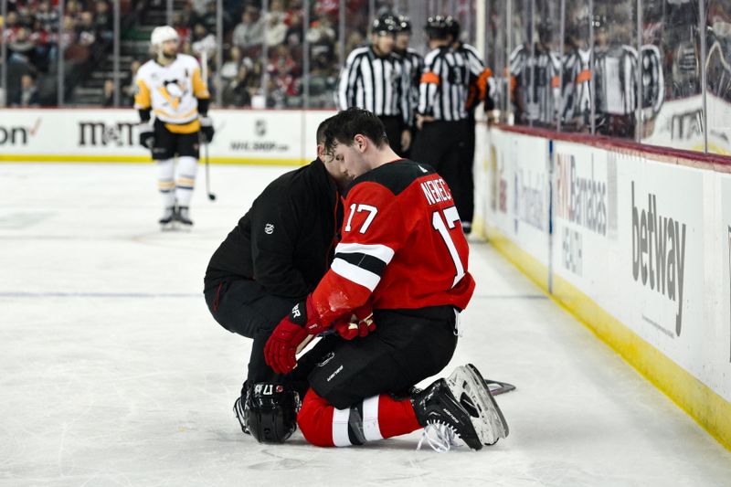 Apr 2, 2024; Newark, New Jersey, USA; New Jersey Devils defenseman Simon Nemec (17) receives medical attention during the third period against the Pittsburgh Penguins at Prudential Center. Mandatory Credit: John Jones-USA TODAY Sports