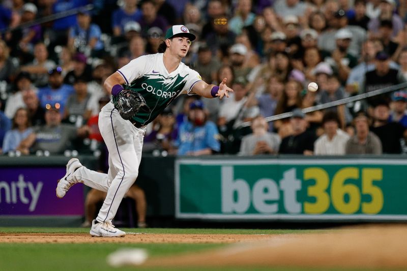 Jul 6, 2024; Denver, Colorado, USA; Colorado Rockies first baseman Michael Toglia (4) tosses the ball to first for the final out in the ninth inning against the Kansas City Royals at Coors Field. Mandatory Credit: Isaiah J. Downing-USA TODAY Sports