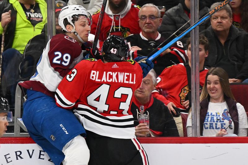 Dec 19, 2023; Chicago, Illinois, USA; Chicago Blackhawks forward Colin Blackwell (43) checks Colorado Avalanche forward Nathan MacKinnon (29) into the glass during second period at United Center. Mandatory Credit: Jamie Sabau-USA TODAY Sports