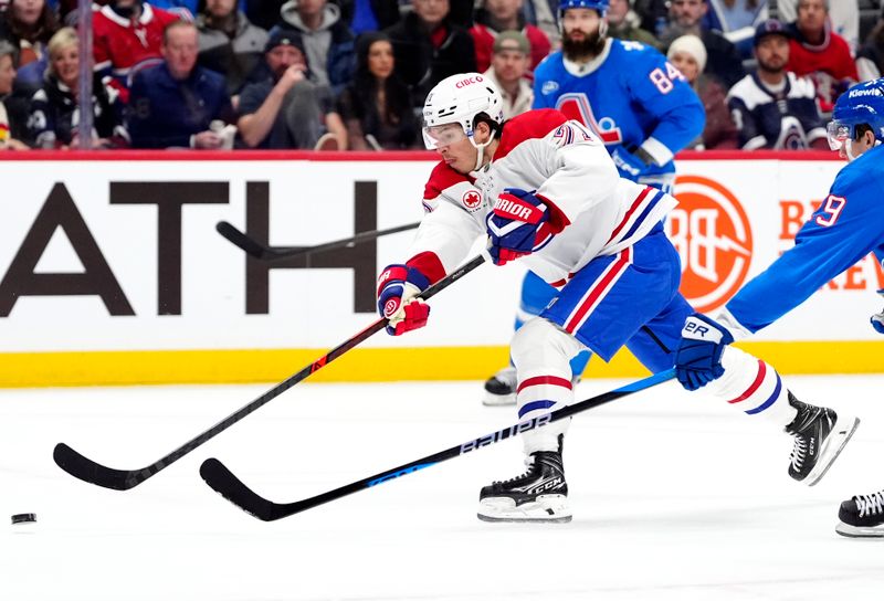 Nov 29, 2025; Denver, Colorado, USA; Montreal Canadiens center Jake Evans (71) shoots the puck in the first period against the Colorado Avalanche at Ball Arena. Mandatory Credit: Ron Chenoy-Imagn Images