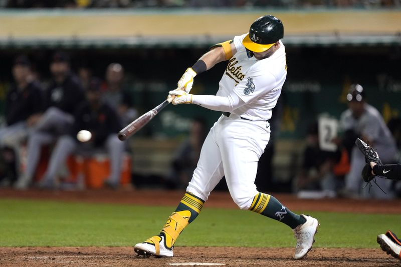 Sep 6, 2024; Oakland, California, USA; Oakland Athletics left fielder Seth Brown (15) hits an RBI single against the Detroit Tigers during the thirteenth inning at Oakland-Alameda County Coliseum. Mandatory Credit: Darren Yamashita-Imagn Images