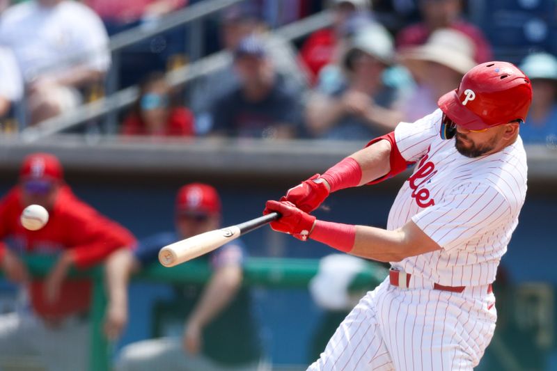 Mar 14, 2024; Clearwater, Florida, USA;  Philadelphia Phillies designated hitter Kyle Schwarber (12) hits an rbi double against the Boston Red Sox in the fourth inning at BayCare Ballpark. Mandatory Credit: Nathan Ray Seebeck-USA TODAY Sports