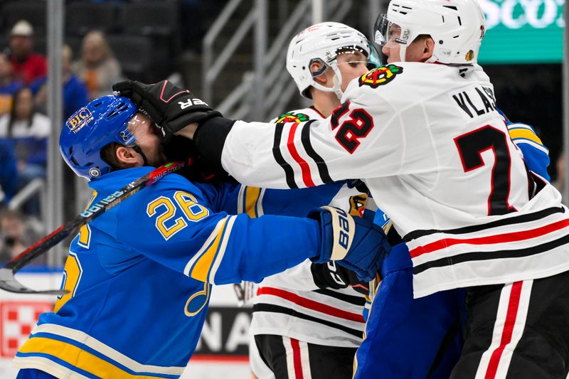 Mar 22, 2025; St. Louis, Missouri, USA;  Chicago Blackhawks defenseman Alex Vlasic (72) and St. Louis Blues left wing Nathan Walker (26) get physical during the second period at Enterprise Center. Mandatory Credit: Jeff Curry-Imagn Images