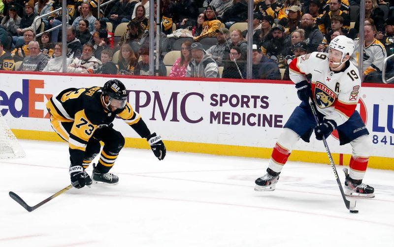 Feb 14, 2024; Pittsburgh, Pennsylvania, USA; Florida Panthers left wing Matthew Tkachuk (19) looks to pass the puck as Pittsburgh Penguins defenseman Pierre-Olivier Joseph (73) defends during the second period at PPG Paints Arena. Florida won 5-2. Mandatory Credit: Charles LeClaire-USA TODAY Sports