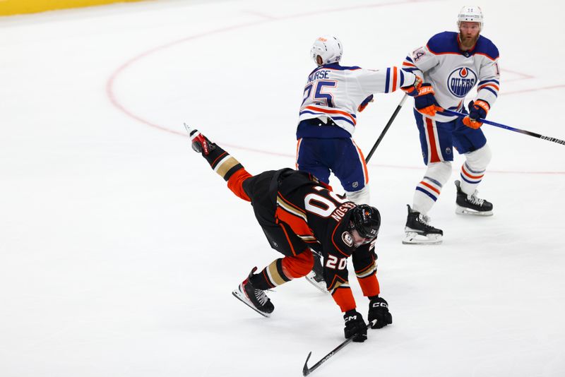 Feb 9, 2024; Anaheim, California, USA; Anaheim Ducks right wing Brett Leason (20) trips over Edmonton Oilers defenseman Darnell Nurse (25) during the third period of a game at Honda Center. Mandatory Credit: Jessica Alcheh-USA TODAY Sports