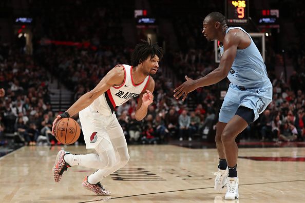 PORTLAND, OREGON - NOVEMBER 05: Shaedon Sharpe #17 of the Portland Trail Blazers drives to the basket as Bismack Biyombo #18 of the Memphis Grizzlies defends during the fourth quarter at Moda Center on November 05, 2023 in Portland, Oregon. NOTE TO USER: User expressly acknowledges and agrees that, by downloading and or using this photograph, User is consenting to the terms and conditions of the Getty Images License Agreement.? (Photo by Amanda Loman/Getty Images)