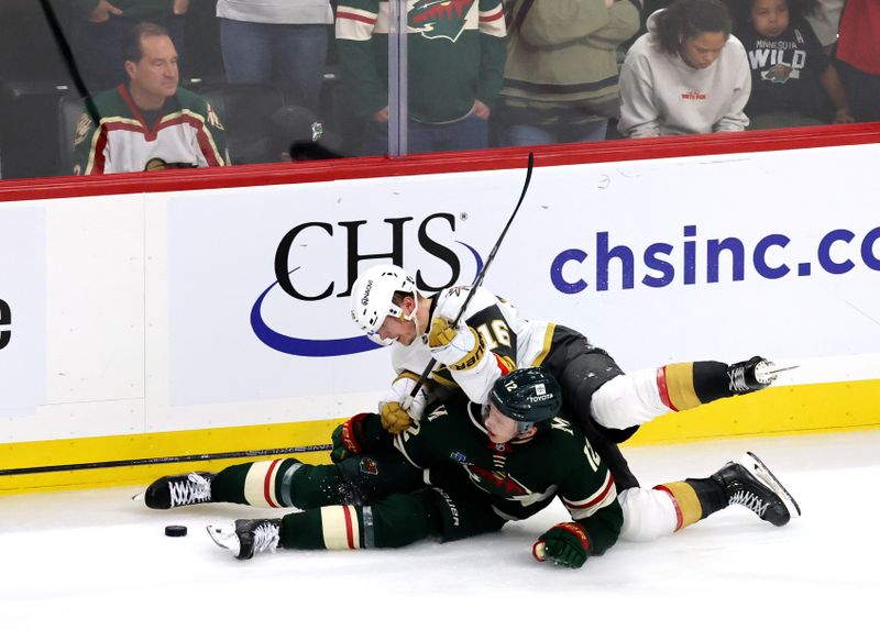 Apr 26, 2025; Saint Paul, Minnesota, USA; Minnesota Wild left wing Matt Boldy (12) is taken down by Vegas Golden Knights left wing Pavel Dorofeyev (16) during 1st OT in game four of the first round of the 2025 Stanley Cup Playoffs at Xcel Energy Center. Mandatory Credit: Bruce Fedyck-Imagn Images
