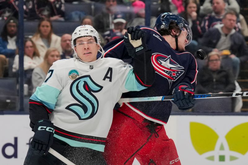 cJan 13, 2024; Columbus, Ohio, USA;  Columbus Blue Jackets left wing Dmitri Voronkov (10) reacts as he is hit by the puck while skating against Seattle Kraken center Yanni Gourde (37) in the second period at Nationwide Arena. Mandatory Credit: Aaron Doster-USA TODAY Sports