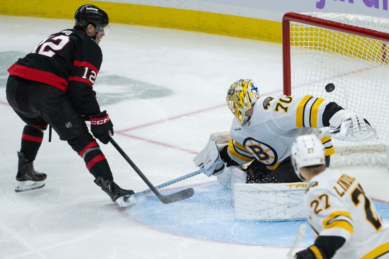Nov 13, 2025; Ottawa, Ontario, CAN;  Ottawa Senators center Shane Pinto (12) scores against Boston Bruins goalie Joonas Korpisalo (70) in the third period at the Canadian Tire Centre. Mandatory Credit: Marc DesRosiers-IMAGN Images