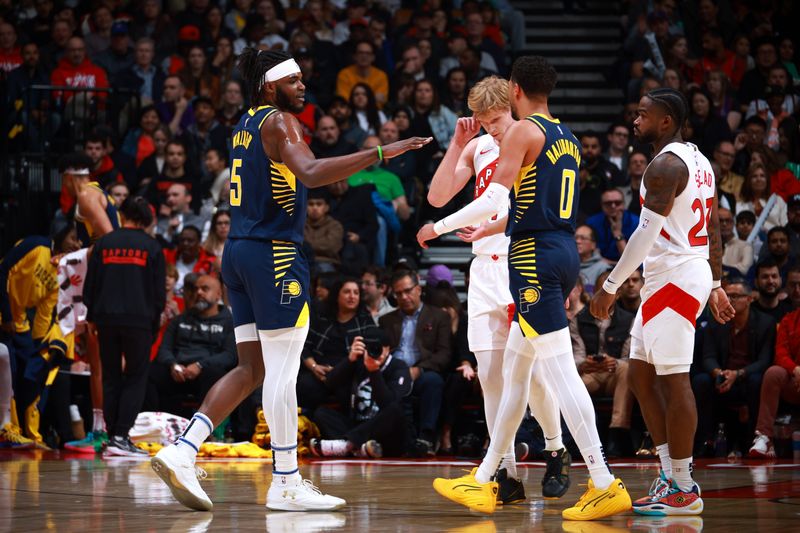 TORONTO, CANADA - NOVEMBER 18: Jarace Walker #5 and Tyrese Haliburton #0 of the Indiana Pacers high five during the game against the Toronto Raptors on November 18, 2024 at the Scotiabank Arena in Toronto, Ontario, Canada.  NOTE TO USER: User expressly acknowledges and agrees that, by downloading and or using this Photograph, user is consenting to the terms and conditions of the Getty Images License Agreement.  Mandatory Copyright Notice: Copyright 2024 NBAE (Photo by Vaughn Ridley/NBAE via Getty Images)