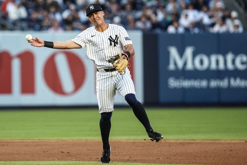 Apr 24, 2024; Bronx, New York, USA; New York Yankees shortstop Anthony Volpe (11) makes an off balanced throw to first base in the first inning against the Oakland Athletics at Yankee Stadium. Mandatory Credit: Wendell Cruz-USA TODAY Sports