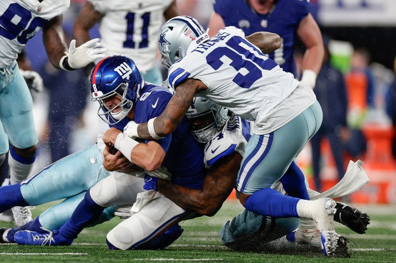 New York Giants quarterback Daniel Jones, left, is sacked during the first half of an NFL football game against the Dallas Cowboys, Sunday, Sept. 10, 2023, in East Rutherford, N.J. (AP Photo/Adam Hunger)