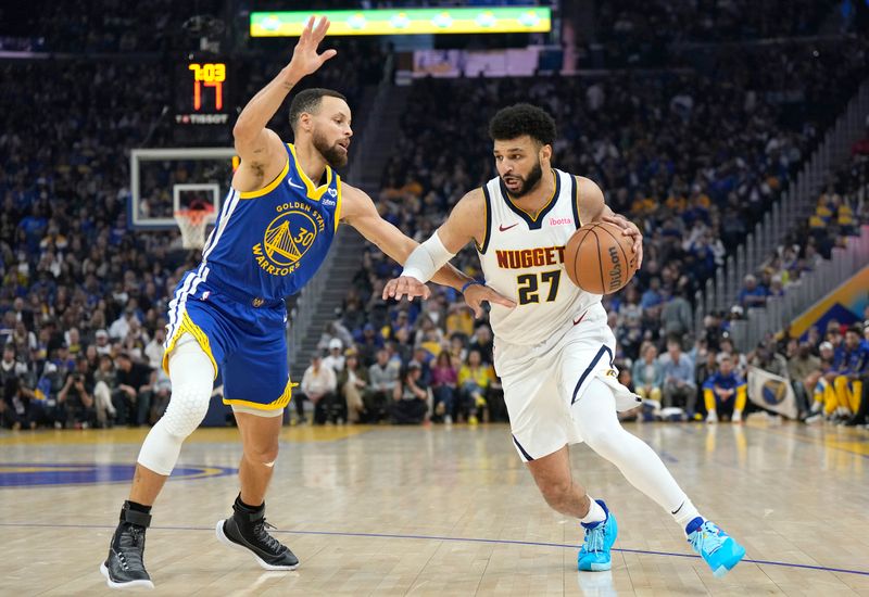 SAN FRANCISCO, CALIFORNIA - FEBRUARY 25: Jamal Murray #27 of the Denver Nuggets dribbles the ball while being guarded by Stephen Curry #30 of the Golden State Warriors in the first quarter of an NBA basketball game at Chase Center on February 25, 2024 in San Francisco, California. NOTE TO USER: User expressly acknowledges and agrees that, by downloading and or using this photograph, User is consenting to the terms and conditions of the Getty Images License Agreement. (Photo by Thearon W. Henderson/Getty Images)