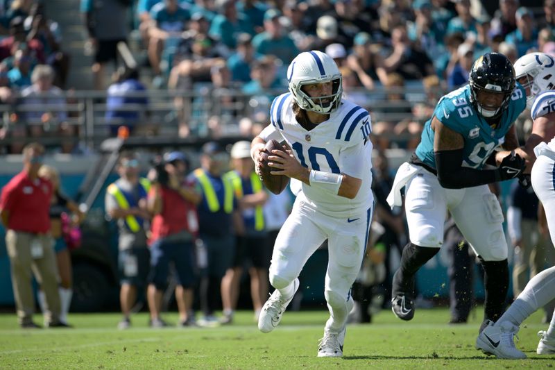 Indianapolis Colts quarterback Gardner Minshew (10) scrambles away from Jacksonville Jaguars defensive end Roy Robertson-Harris (95) during the second half of an NFL football game, Sunday, Oct. 15, 2023, in Jacksonville, Fla. (AP Photo/Phelan M. Ebenhack)