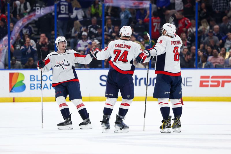 Feb 22, 2024; Tampa, Florida, USA;  Washington Capitals center Connor McMichael (24) celebrates with left wing Alex Ovechkin (8) and defenseman John Carlson (74) after scoring a goal against the Tampa Bay Lightning in the third period at Amalie Arena. Mandatory Credit: Nathan Ray Seebeck-USA TODAY Sports