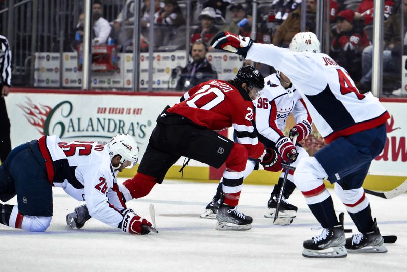 Nov 10, 2023; Newark, New Jersey, USA; New Jersey Devils center Michael McLeod (20) competes for the puck with Washington Capitals right wing Nic Dowd (26) during the second period at Prudential Center. Mandatory Credit: John Jones-USA TODAY Sports