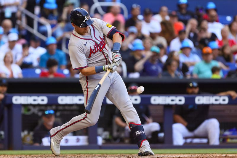 Apr 14, 2024; Miami, Florida, USA; Atlanta Braves third baseman Austin Riley (27) hits a single against the Miami Marlins during the seventh inning at loanDepot Park. Mandatory Credit: Sam Navarro-USA TODAY Sports