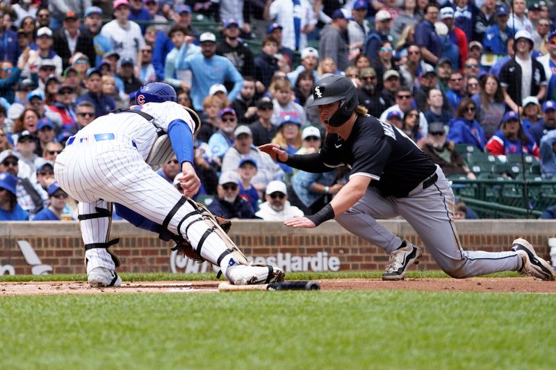 May 18, 2025; Chicago, Illinois, USA; Chicago Cubs catcher Carson Kelly (15) prepares to tag out Chicago White Sox shortstop Chase Meidroth (10) at home plate during the first inning at Wrigley Field. Mandatory Credit: David Banks-Imagn Images