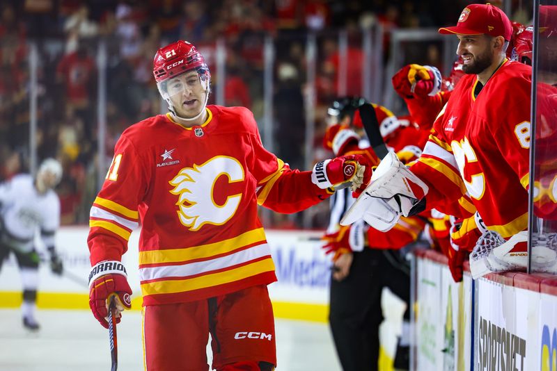 Nov 11, 2024; Calgary, Alberta, CAN; Calgary Flames center Kevin Rooney (21) celebrates his goal with teammates during the third period against the Los Angeles Kings at Scotiabank Saddledome. Mandatory Credit: Sergei Belski-Imagn Images