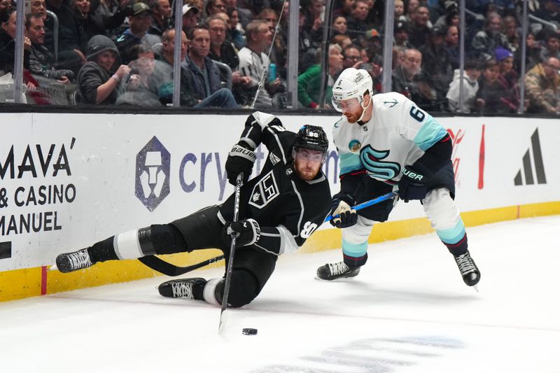 Dec 20, 2023; Los Angeles, California, USA; LA Kings center Pierre-Luc Dubois (80) reaches for the puck against Seattle Kraken defenseman Adam Larsson (6) in the second period at Crypto.com Arena. Mandatory Credit: Kirby Lee-USA TODAY Sports