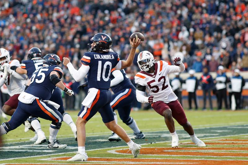 Nov 25, 2023; Charlottesville, Virginia, USA; Virginia Cavaliers quarterback Anthony Colandrea (10) passes the ball from his own end zone as Virginia Tech Hokies defensive lineman Antwaun Powell-Ryland (52) chases during the second quarter at Scott Stadium. Mandatory Credit: Geoff Burke-USA TODAY Sports