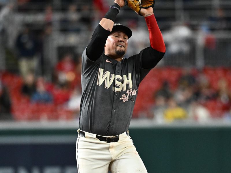 Sep 27, 2024; Washington, District of Columbia, USA;  Washington Nationals third baseman Ildemaro Vargas (14) makes a catch during the eighth inning against the Philadelphia Phillies at Nationals Park. Mandatory Credit: James A. Pittman-Imagn Images