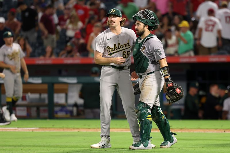 Jul 25, 2024; Anaheim, California, USA;  Oakland Athletics relief pitcher Tyler Ferguson (65) and catcher Shea Langeliers (23) celebrate a victory after defeating the Los Angeles Angels 6-5 at Angel Stadium. Mandatory Credit: Kiyoshi Mio-USA TODAY Sports