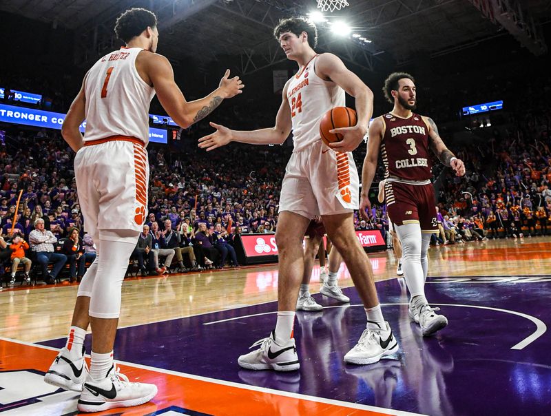 Jan 13, 2024; Clemson, South Carolina, USA; Clemson Tigers guard Chase Hunter (1) celebrates with center PJ Hall (24) as Boston College Eagles guard Jaeden Zackery (3) looks on during the second half at Littlejohn Coliseum. Mandatory Credit: Ken Ruinard-USA TODAY Sports