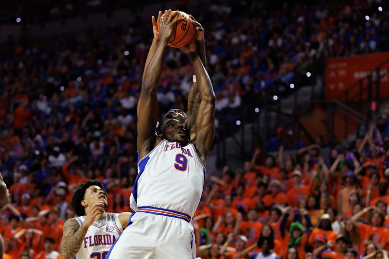 Feb 14, 2026; Gainesville, Florida, USA; Florida Gators center Rueben Chinyelu (9) grabs a rebound over Kentucky Wildcats guard Otega Oweh (00) during the second half at Exactech Arena at the Stephen C. O'Connell Center. Mandatory Credit: Matt Pendleton-Imagn Images