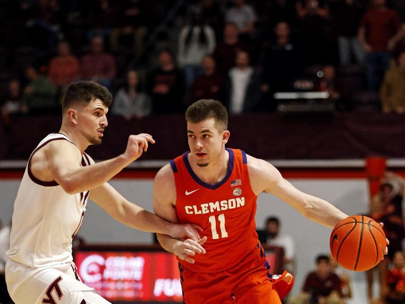 Jan 10, 2024; Blacksburg, Virginia, USA; Clemson Tigers guard Joseph Girard III (11) handles the ball against Virginia Tech Hokies guard Hunter Cattoor (0) during the first half at Cassell Coliseum. Mandatory Credit: Peter Casey-USA TODAY Sports