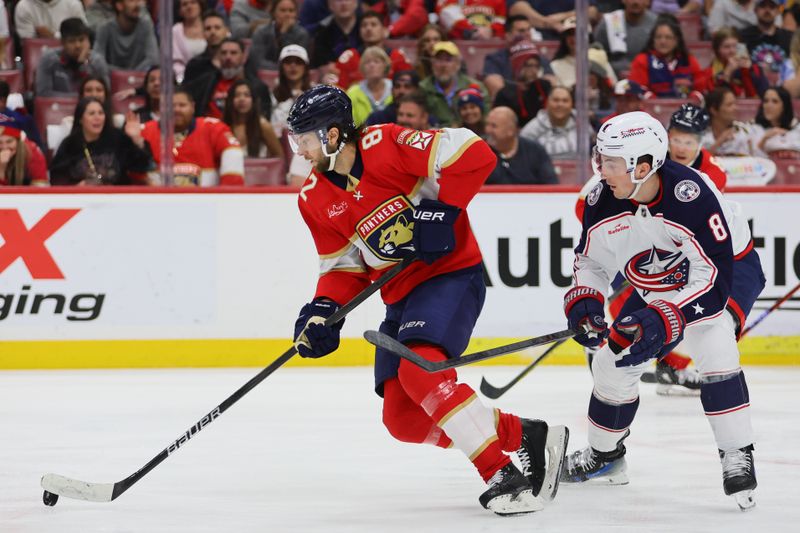 Apr 11, 2024; Sunrise, Florida, USA; Florida Panthers center Kevin Stenlund (82) moves the puck past Columbus Blue Jackets defenseman Zach Werenski (8) during the second period at Amerant Bank Arena. Mandatory Credit: Sam Navarro-USA TODAY Sports