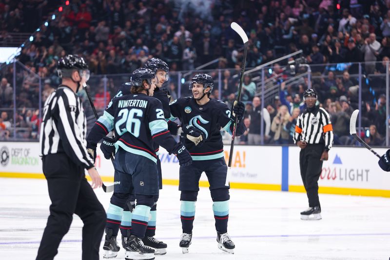 Nov 3, 2025; Seattle, Washington, USA; Seattle Kraken defenseman Joshua Mahura (28) and center Ryan Winterton (26) celebrate a goal scored by defenseman Jamie Oleksiak (24) in the second period against the Chicago Blackhawks at Climate Pledge Arena. Mandatory Credit: Kevin Ng-Imagn Images